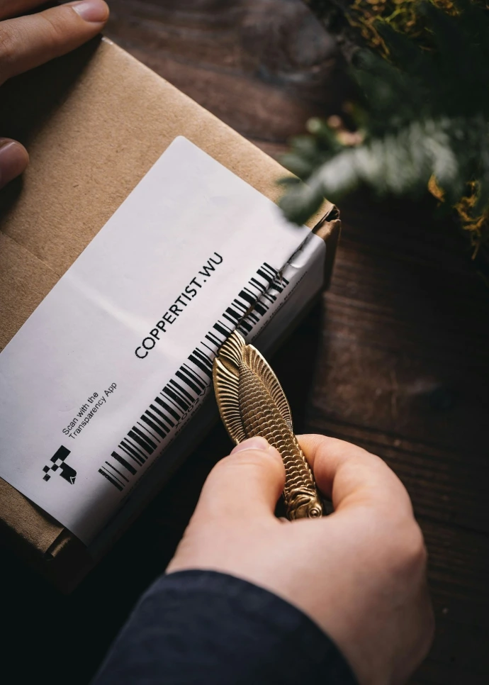 a person is holding a golden pen in their hand